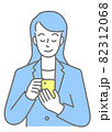 スマホを操作する、スーツを着た若い女性の上半身（色付き） 82312068