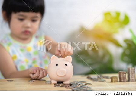cute asia baby girl drop coins in piggy bank,saving concept. 82312368