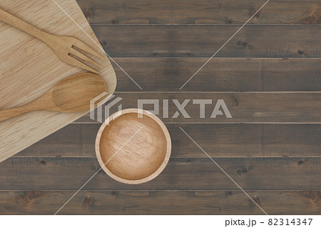 kitchenware : spoon, fork, cup, chopsticks and cutting board placed on wooden table 82314347