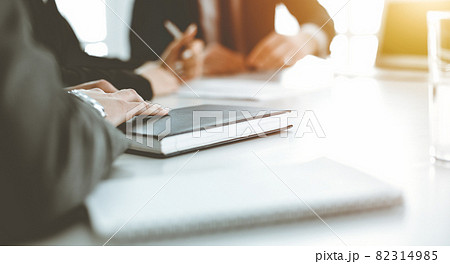 Unknown businessmen and woman sitting, working and discussing questions at meeting in sunny office, close-up. Success concept 82314985