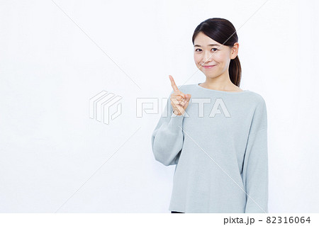笑顔で指差しをしている30代の女性 82316064