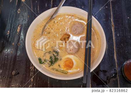 Pork noodle tom yum with egg on blurred wooden 82316862