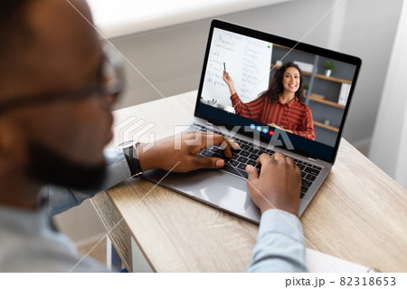 Cropped afro american male student watch online lecture with virtual class and multiracial teacher on computer screen Cropped afro american male student watch online lecture with virtual class and multiracial teacher on computer screen 82318653