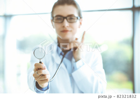Beautiful woman doctor with stethoscope smiling charmingly and ready to help patients in the modern hospital. Medicine concept 82321832