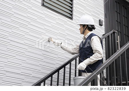 刷毛で戸建て住宅の外壁を塗る塗装職人 82322839