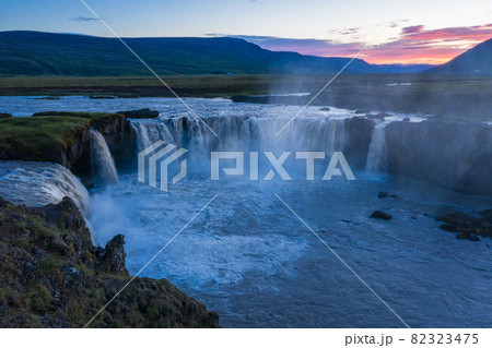 The aerial view of the beautiful waterfall of Godafoss at link sunset, Iceland in the summer season The aerial view of the beautiful waterfall of Godafoss at link sunset, Iceland in the summer season 82323475