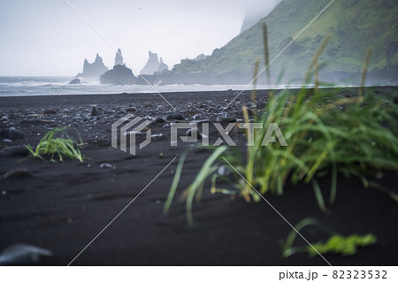 Black beach in Vik with famous Reynisdrangar rock formations and the mount Reynisfjall in stormy ocean. Southern Iceland 82323532