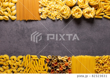 Raw pasta assortment at stone tabletop. Pasta collection food at table background 82323631