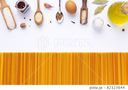 Raw pasta spaghetti and ingredients food at white background. Pasta recipe concept Raw pasta spaghetti and ingredients food at white background. Pasta recipe concept 82323644