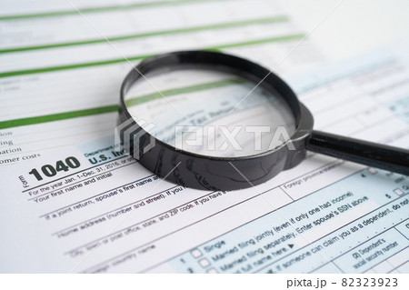 Tax Return form 1040 and dollar banknote, U.S. Individual Income. 82323923