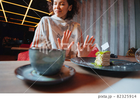 Dieting or good health concept. Young woman rejecting Junk food or unhealthy food such as dessert 82325914