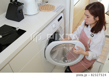 asian wife using the washing machine asian wife using the washing machine 82327324
