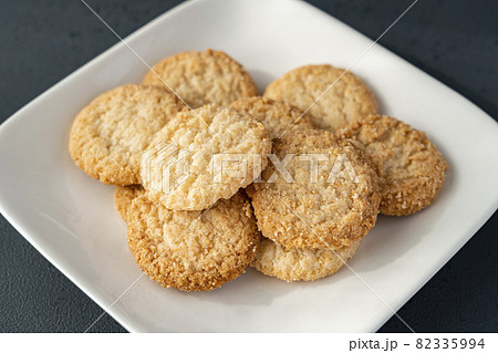 白いお皿にのった全粒粉クッキー 黒背景 の写真素材