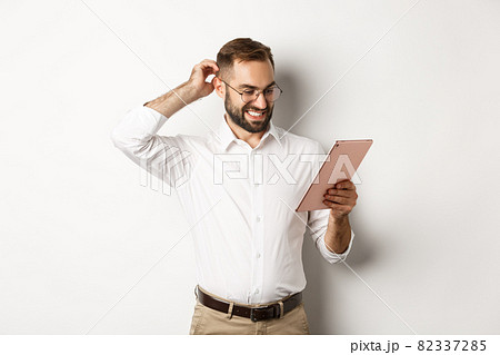 Confused male manager looking puzzled at digital tablet, scratching head doubtful, standing over white background Confused male manager looking puzzled at digital tablet, scratching head doubtful, standing over white background 82337285
