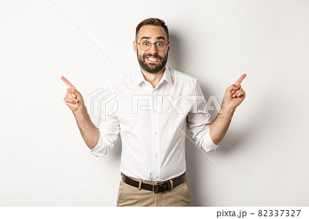 Indecisive businessman pointing sideways, showing two variants, struggling make choice, standing over white background Indecisive businessman pointing sideways, showing two variants, struggling make choice, standing over white background 82337327