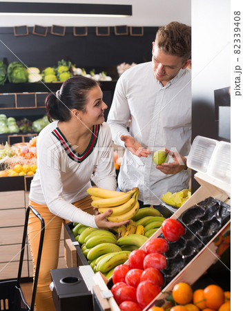 Friendly couple deciding on fruits in shop 82339408