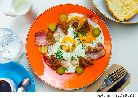 Russian cuisine - scrambled eggs with bacon, croutons and pickled 82339631
