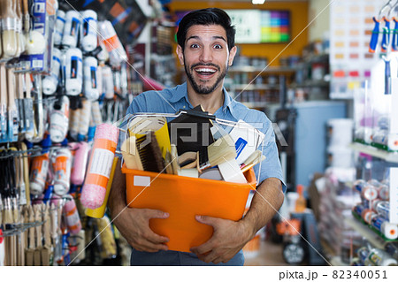 Satisfied guy handyman holding basket with tools Satisfied guy handyman holding basket with tools 82340051