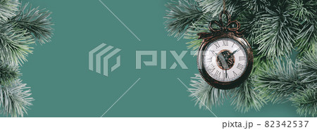 Christmas ornaments clock on green branch background 82342537