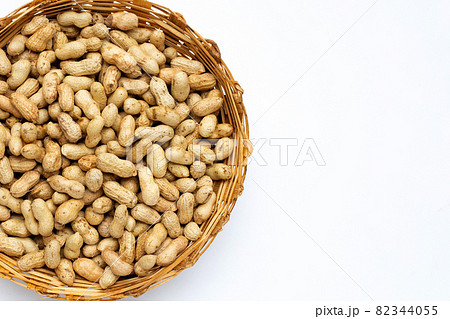 Raw peanuts in bamboo basket on white background. Raw peanuts in bamboo basket on white background. 82344055