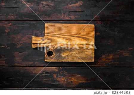 Rustic cutting board, top view flat lay , with copy space for text or food, on old dark wooden table background Rustic cutting board, top view flat lay , with copy space for text or food, on old dark wooden table background 82344203