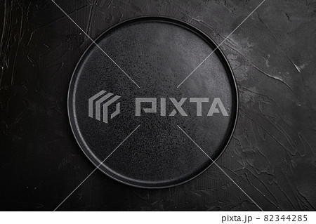 Top view of black plate, on black dark stone table background 82344285
