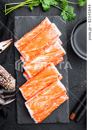 Crab sticks seafood semi finished fish mince with blue swimming crab, on stone board, on black background, top view flat lay 82345844