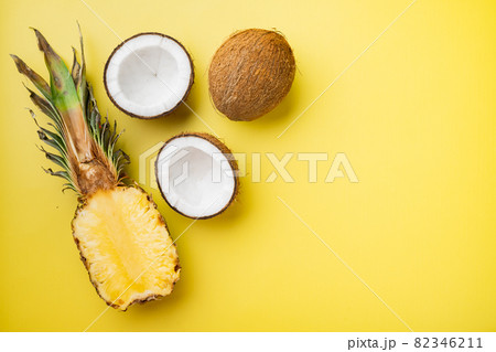 Fresh fruits, pineapple and Coconut, on yellow textured summer background, top view flat lay, with copy space for text 82346211