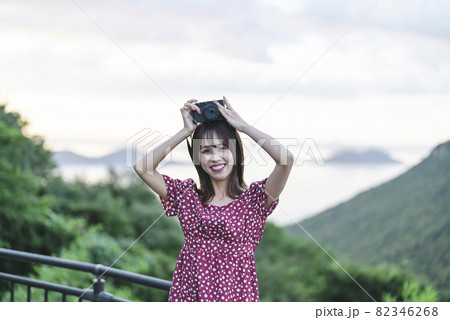 夕暮れの観光地にいるカメラ女子 82346268