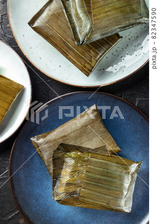 Tamales oaxaquenos, traditional Hispanic dish, wrapped in green leaves Tamales oaxaquenos, traditional Hispanic dish, wrapped in green leaves 82347590
