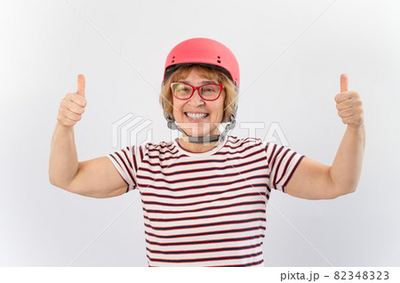 Elderly woman in ski helmet showing thumb up on white background. Elderly woman in ski helmet showing thumb up on white background. 82348323