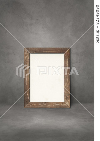 Wooden picture frame leaning on a dark concrete wall Wooden picture frame leaning on a dark concrete wall 82349090