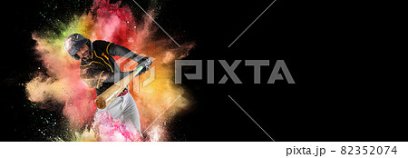 Professional baseball player in sports equipment training in explosion paint and colorful powder. Sport, fashion, show concept 82352074