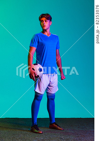 Young Caucasian soccer football player posing isolated on blue background 82353076