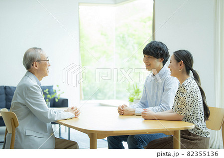 会話するシニア男性と若い夫婦 82355136