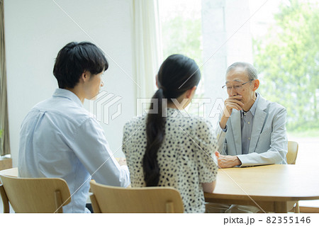 会話するシニア男性と若い夫婦 会話するシニア男性と若い夫婦 82355146