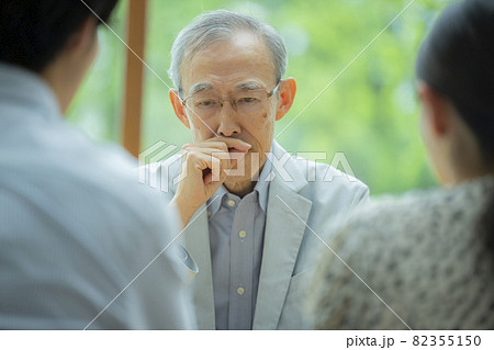 会話するシニア男性と若い夫婦 82355150