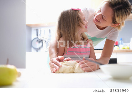 Little girl and mom making dough pie at home Little girl and mom making dough pie at home 82355940