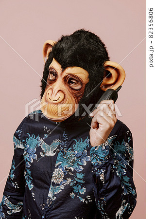 man wearing a monkey mask speaks in a mobile phone man wearing a monkey mask speaks in a mobile phone 82356806