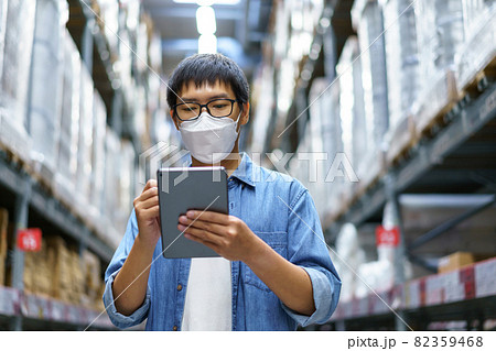 New Normal Asian men, staff, product wearing face mask. counting Warehouse Control Manager Standing, counting and inspecting products in the warehouse 82359468