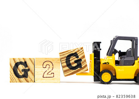 Toy forklift hold letter block G to complete word G2G (abbreviation of Government to government) on wood background 82359638