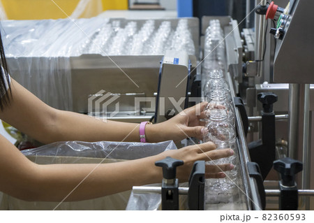 The operation put the empty PET bottles to the conveyor belt for filling process in the drinking water factory. 82360593