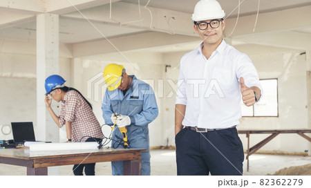 Asian engineer man brainstorming construction building contractor civil worker parners team meeting at constrcution site. Blueprint engineer hardhat worker helmet on table. Engineer teamwork consult Asian engineer man brainstorming construction building contractor civil worker parners team meeting at constrcution site. Blueprint engineer hardhat worker helmet on table. Engineer teamwork consult 82362279