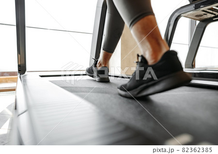 Close up of male legs running in a gym on a treadmill 82362385