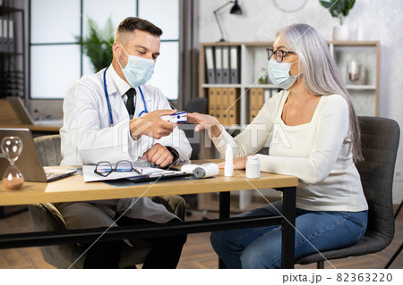 Doctor measuring pulse and oxygen saturation to aged woman 82363220