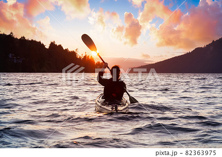 Adventurous Woman on Sea Kayak paddling in the Pacific Ocean. Adventurous Woman on Sea Kayak paddling in the Pacific Ocean. 82363975