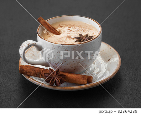 Masala chai tea close up. Traditional Indian drink with spices and milk on a dark background. 82364239
