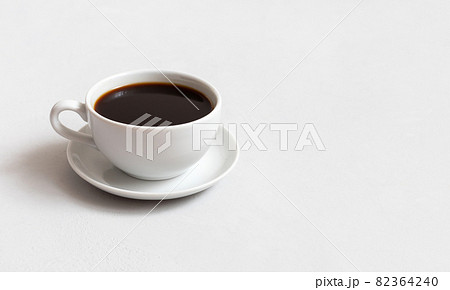 Cup of hot coffee on a white concrete background. Black coffee in a small cup. Copy space. Cup of hot coffee on a white concrete background. Black coffee in a small cup. Copy space. 82364240