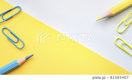 Yellow blue geometric background with yellow and blue pencils and paper clips. Yellow blue geometric background with yellow and blue pencils and paper clips. 82365407