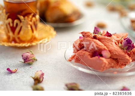 Assortment of Turkish delights with glass of tea on gray background Assortment of Turkish delights with glass of tea on gray background 82365636